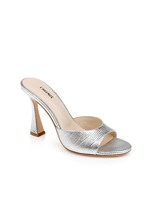 The Avery Leather Open-Toe Mule is a silver lizard-embossed sandal with a sculpted high heel and L’AGENCE branding on the insole, shown on a white background.