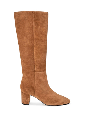The Eugenie Block-Heel Boot—a tall, tan suede boot with a rounded toe and mid-height block heel—offers effortless fall-to-winter style, shown in profile against a white background.