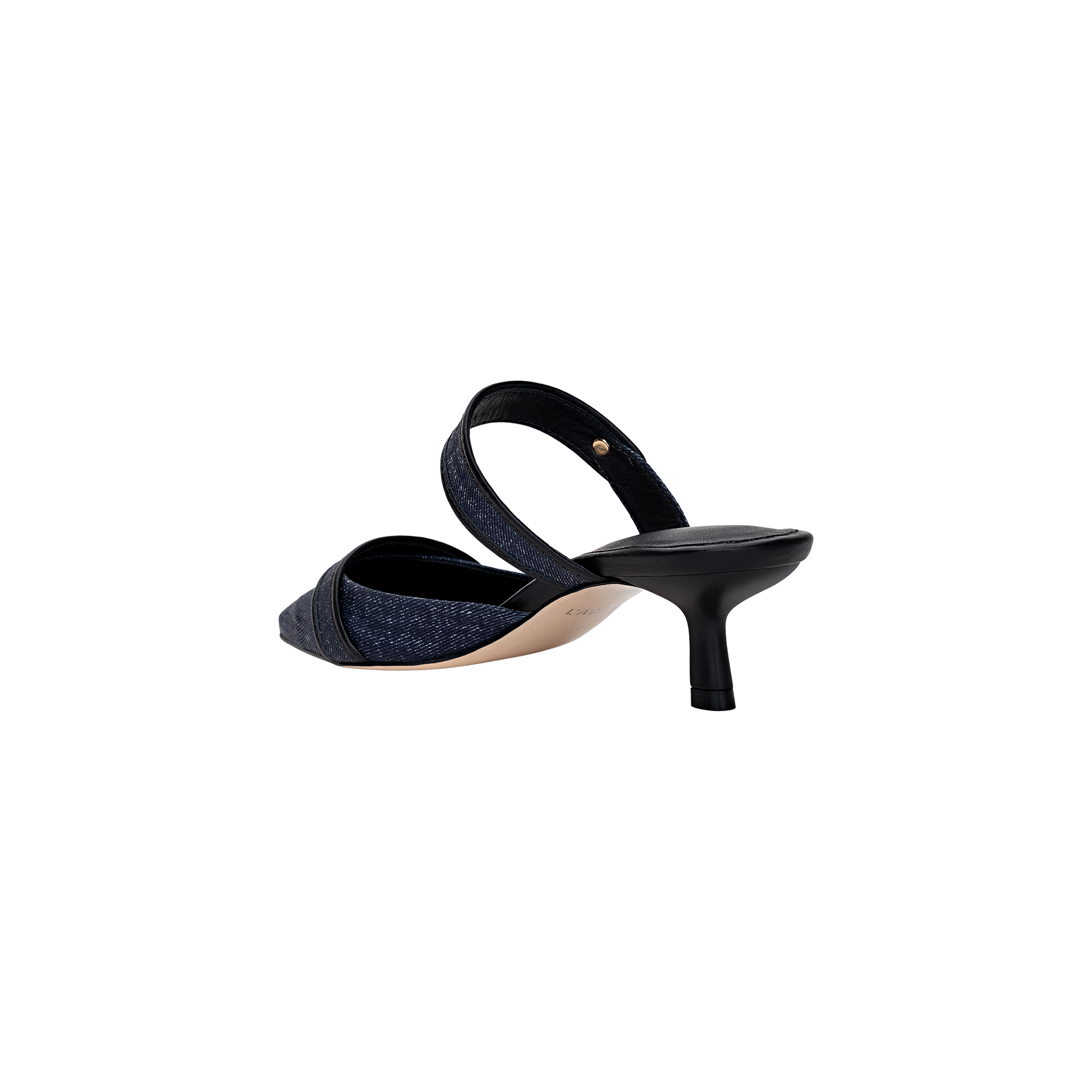 The Gilliane Heeled Mule is a vintage-inspired shoe crafted from dark denim, featuring a pointed toe, open back, and a mid-height black kitten heel. It is shown from the rear at an angle on a plain white background.