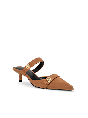 The Gilliane Heeled Mule is a vintage-inspired tan suede mule with a low kitten heel, pointed toe, black trim, and two lion-embossed buttons on adjustable straps across the front and instep, shown on a white background.