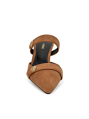 Front view of the Gilliane Heeled Mule in tan suede, featuring two straps with lion-embossed gold buttons, a pointed-toe slip-on design, black insole, and elegant vintage-inspired decorative details.