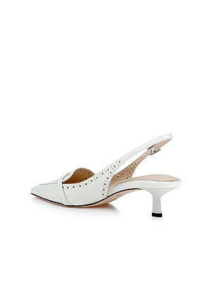 The L'AGENCE Lourdes Leather Slingback Pump features white leather, a pointed toe, side perforations, and a buckle strap. It has a tan interior and a short curved kitten heel. Shown against a plain white background.