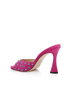 The Lucienne Embellished Suede Mule is a vibrant pink open-toe heel with a flared heel, blue and turquoise strap embellishments, beige lining, and a light brown sole.