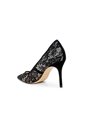 The Maelle Lace Pump, a black pointed-toe stiletto, showcases elegant floral lace. Photographed on a white background, it's perfectly angled to highlight its slim heel and classic side and back profile.