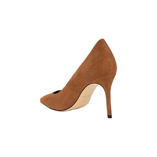 The Maelle Suede Pump showcases rich brown suede and a pointed toe, photographed from the back right side against a plain white background. Its stiletto heel and smooth, curved lines are clearly visible.