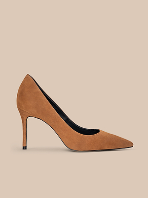 The Maelle Suede Pump is a classic brown suede shoe with a pointed toe and slim stiletto heel, shown against a beige background.