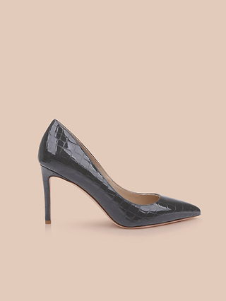 The Maelle Leather Pump, crafted in black crocodile-embossed leather with a pointed toe and stiletto heel, is shown in profile on a plain light peach background.