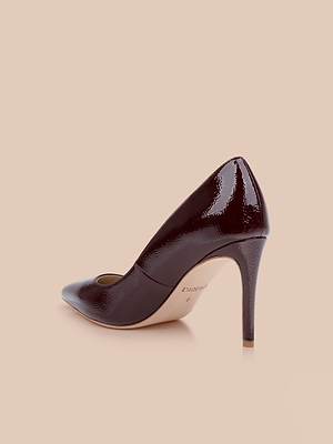 يظهر حذاء Maelle Leather Pump، المصنوع من الجلد الأحمر النبيذي اللامع مع مقدمة مدببة وكعب بكعب مدبب، على خلفية باللون البيج الفاتح من زاوية تبرز الجانب الخارجي والظهر.