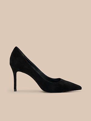The Maelle Suede Pump, shown in profile against a plain beige background, is a classic black suede shoe with a pointed toe and slim stiletto heel.