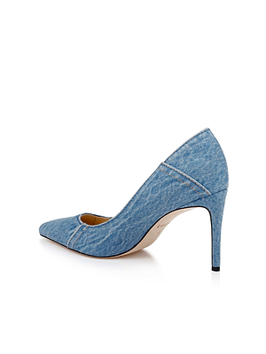 The Maelle Denim Pump by L'AGENCE showcases a pointed toe and sleek stiletto heel, displayed in side profile against a white background.