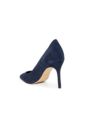 The Maelle Suede Pump by L'AGENCE is a navy blue pointed-toe stiletto with a beige sole, shown from the back and side to highlight its slim heel, all set against a white background.