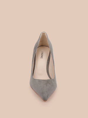 The Maelle Suede Pump in smoke grey features a pointed toe, stiletto heel, and beige insole with the brand name. Presented from the front on a light peach background.