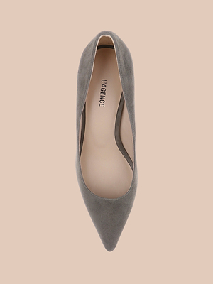 A top view of the Maelle Suede Pump in smoke grey with a pointed toe, beige insole labeled LAGENCE, displayed on a light peach background.