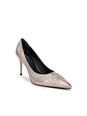 The L'AGENCE Amandine Western Pump is a metallic gold pointed-toe stiletto with stitched swirl details, inspired by classic Western suede pumps and shown on a white background.