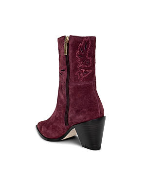 The Anne Western Bootie is shown from a side-back angle on a white background, featuring maroon suede, a pointed toe, side zipper, embroidered shaft, and chunky angled heel.