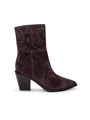 The Anne Western Bootie features dark brown suede, a pointed toe, decorative stitching, cutout shaft details, and a chunky angled heel for a modern take on classic Western style.