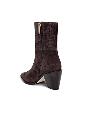 The Anne Western Bootie features dark brown suede, a side zipper, decorative stitching, and a chunky angled heel for a modern update on classic Western style—shown here against a white background.