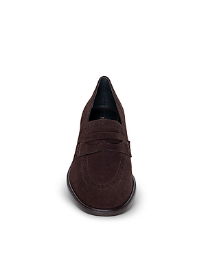 A front view of the Avriel Brogue Loafer in dark brown suede, showcasing an almond toe, decorative strap, and subtle stitching details, set against a plain white background.