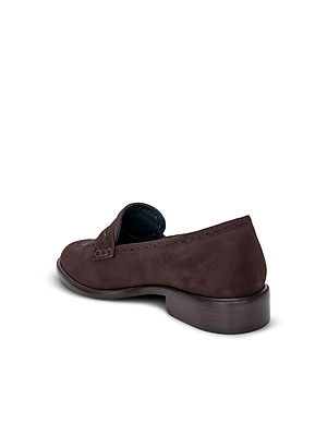 The Avriel Brogue Loafer, shown from a back side angle against a plain white background, is a dark brown suede loafer with subtle brogueing, an almond toe, and a low wooden heel.
