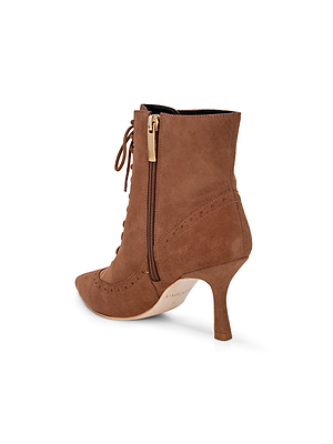 The Fayette Lace-Up Bootie features brown suede, a pointed toe, lace-up front, side zipper with gold pull, vintage-inspired brogue perforations, and a slender high heel.
