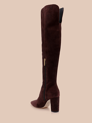 The Nanette Boot is a tall, mahogany brown suede boot featuring a side zipper and a rounded block heel, displayed in profile against a beige background.