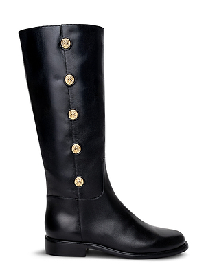 The Oceana Riding Boot by L'AGENCE is a tall black leather boot with a low heel, five gold lion-embossed buttons on the outer side, a sleek polished finish, and a rounded toe.