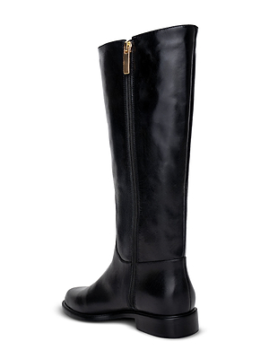 The Oceana Riding Boot by L'AGENCE is a black knee-high boot with a low heel, gold side zipper, and lion-embossed buttons, shown from the back side against a white background.