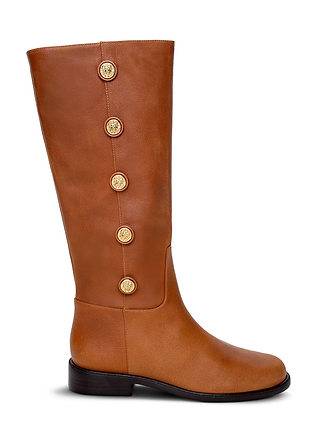 The Oceana Riding Boot is a tall silhouette crafted from rich cognac leather, featuring five gold lion-embossed buttons running vertically along the side, a low black heel, and a smooth rounded toe.