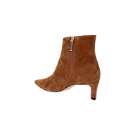 The Lilly Kitten-Heel Bootie is a brown suede ankle boot featuring a pointed toe, side zipper, and a mid-height kitten heel, displayed on a plain white background.