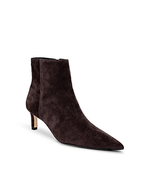 The L'AGENCE Lilly Kitten-Heel Bootie features dark brown suede, a pointed toe, and a slim kitten heel, shown against a white background.