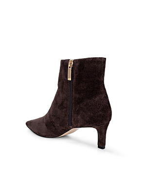 The L'AGENCE Lilly Kitten-Heel Bootie, in dark brown suede, features a pointed toe, side zipper with gold pull, and a slender low heel. Shown on a white background.