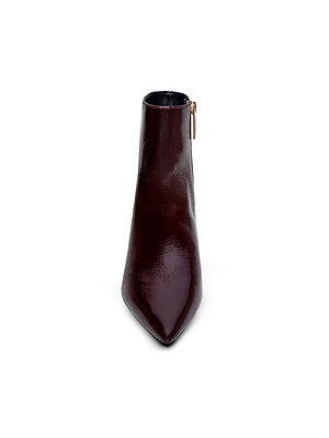 The Lilly Kitten-Heel Bootie by L'AGENCE features shiny burgundy patent leather, a pointed toe, side zipper, and kitten heel, shown from the front on a plain white background.