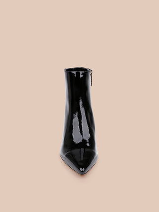 The Lilly Kitten-Heel Bootie, crafted in glossy black patent leather with a pointed toe, is shown from the front against a plain beige background.