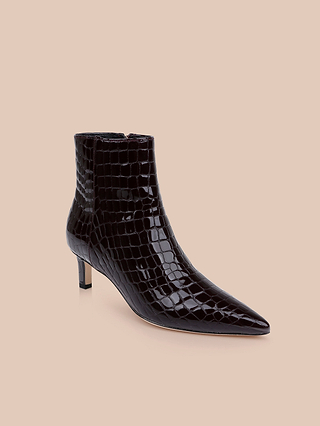 The Lilly Kitten-Heel Bootie, crafted in black crocodile-embossed leather with a pointed toe and low kitten heel, is displayed on a light beige background.