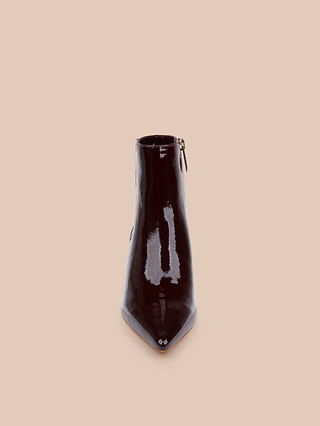 La bottine à talon bas Lilly — une bottine de ville unique, de couleur bordeaux foncé brillant, à bout pointu et dotée dune fermeture éclair sur le côté, confectionnée en cuir verni — est présentée debout sur un fond beige uni.