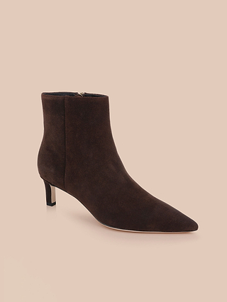 Gli stivaletti Lilly con tacco kitten, un modello da città in pelle scamosciata marrone scuro caratterizzato da punta affusolata e tacco kitten basso e slanciato, sono presentati su uno sfondo beige chiaro.