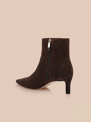 Stivaletti Lilly con tacco kitten in pelle scamosciata marrone scuro, caratterizzati da punta affusolata, tacco kitten di media altezza e cerniera laterale, presentati su uno sfondo beige chiaro.