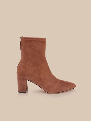 The Salome Stretch Suede Boot, a chic brown ankle boot featuring a block heel and pointed toe, is shown in side profile against a beige background.