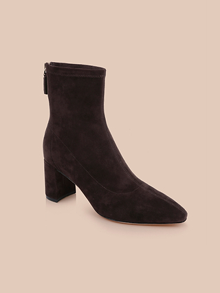 Introducing the Salome Stretch Suede Boot: a chic black ankle boot crafted from stretch suede, featuring a sturdy block heel and convenient side zipper, beautifully displayed against a beige background.