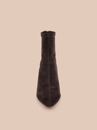 The Salome Stretch Suede Boot, a single dark brown ankle boot featuring a stylish block heel, is displayed upright and facing forward against a solid light beige background.