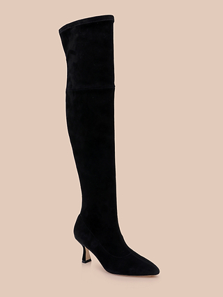 The Clarin Over-the-Knee Boot is shown in black suede, featuring a pointed toe and a short, slender heel, displayed on a beige background.