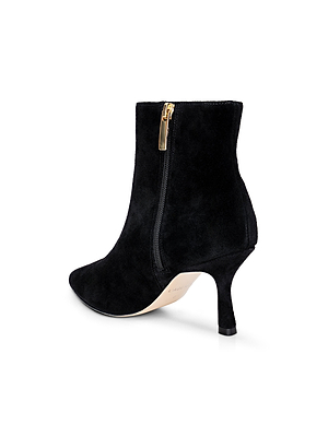 The Sylvie Suede Bootie by L'AGENCE is a minimalist black ankle boot with a pointed toe, gold side zipper, and mid-height stiletto heel, shown on a white background.