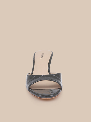 The Arleen Kitten-Heel Mule is a single black open-toe mule sandal crafted from crocodile-embossed leather with a textured pattern, featuring a tan memory foam insole and low kitten heel, photographed from the front against a beige background.