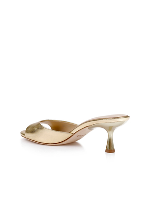 The Arleen Kitten-Heel Mule is a gold leather sandal with an open toe, low curved heel, and sleek minimalist design, shown on a white background.