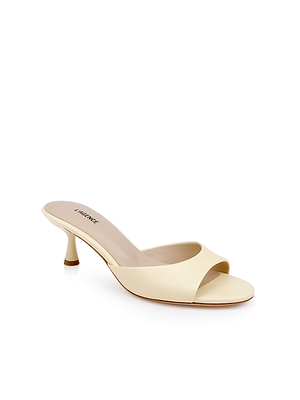 The Arleen Kitten-Heel Mule is a beige leather open-toe sandal with a mid-height kitten heel and minimalist design, shown against a white background.