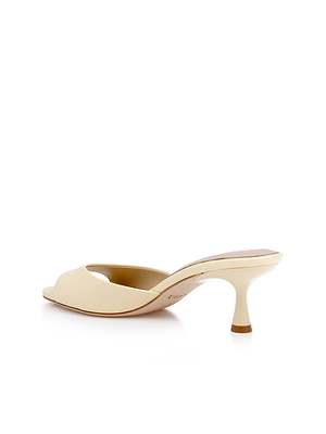 The Arleen Kitten-Heel Mule is a single beige leather open-toe shoe with a low, curved kitten heel, shown from the side and slightly behind on a white background.