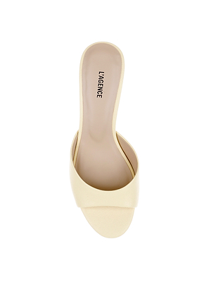 Top view of a single Arleen Kitten-Heel Mule in beige leather with an open toe and wide front strap. LAGENCE is printed in black on the insole. This heeled sandal is shown on a white background.