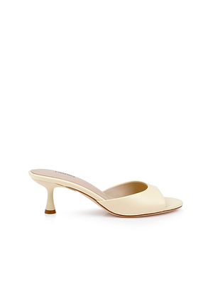 The Arleen Kitten-Heel Mule is a light beige leather sandal with an open toe, kitten heel, and minimalist design, shown on a white background.
