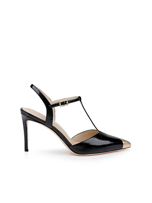 The Kaveh Slingback Pump features black patent leather, a pointed gold metallic toe, T-strap design, and an ankle strap with a small buckle—offering elegance and sophistication with its slim stiletto heel.