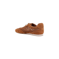 The Jarah Sneaker is crafted in brown suede with a white sole and beige laces, displayed at an angle to showcase both the side and back. Its side panel features a textured, perforated design, while a comfortable memory foam insole adds modern comfort to this retro-inspired style. The image is set against a plain white background.